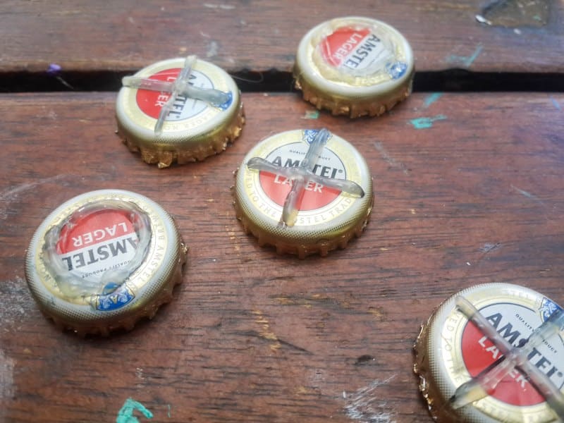 Use a glue gun to draw X and Os on the bottle tops