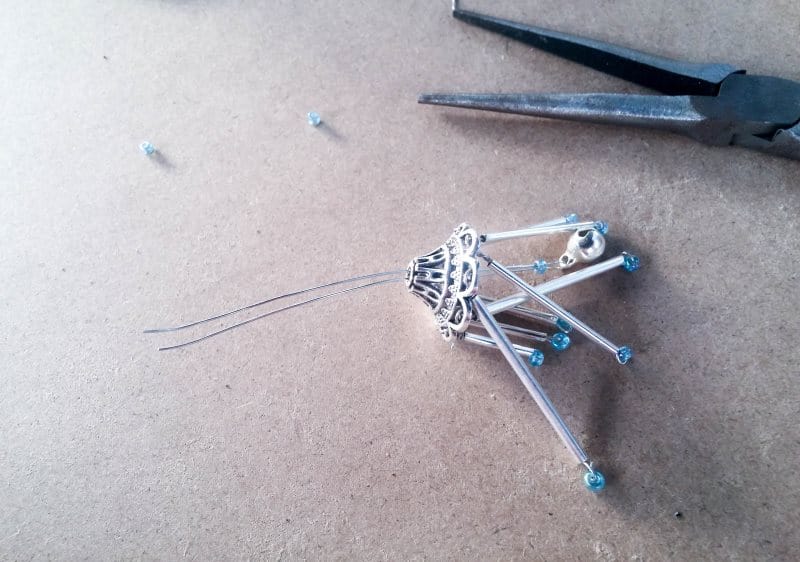 Thread the bell on the wire up into the middle hole in the space bead