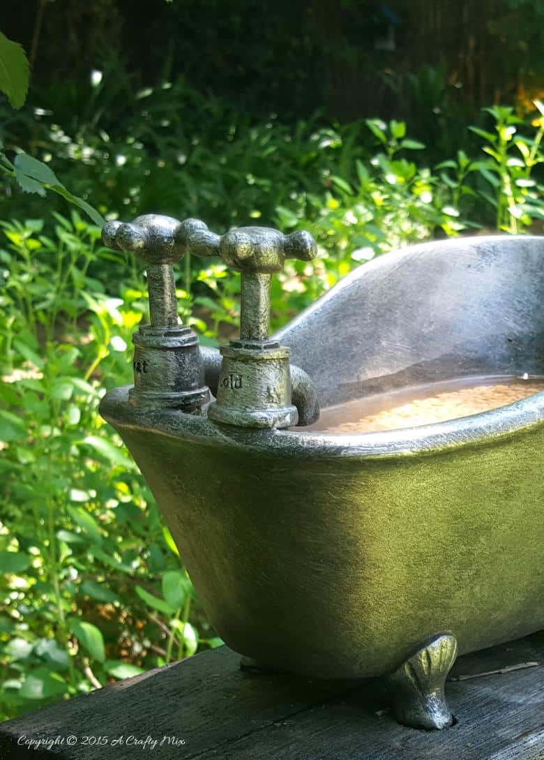 How to repurpose a bathroom accessory into a unique bird bath feature. #DIYOutdoors #BirdBathDIY #ACraftyMix #GardenFeature #Repupose