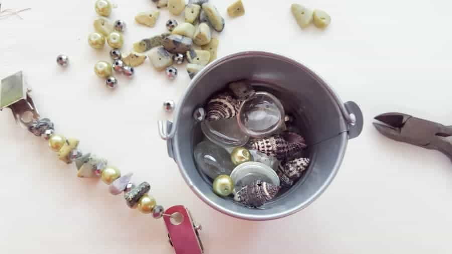 Fill the bucket with beads on glass stones FInd a selection of beads and string onto the wire #tableclothweights #tabledecor #DIYTableClothWeights #SpringDecor