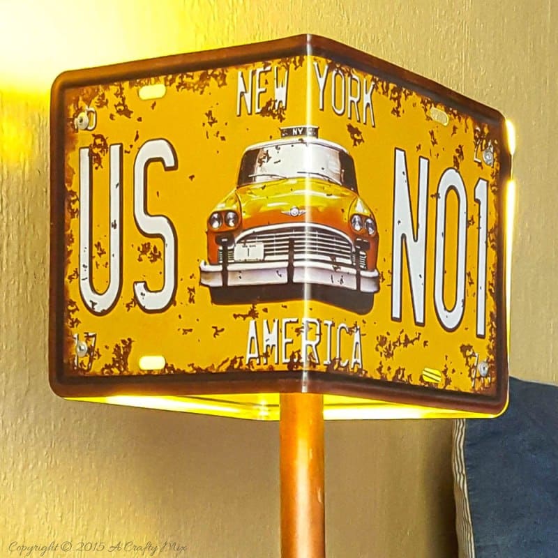 Add a little industrial chic to your decor and make this license plate lamp using pipes. Perfect for a teens room or man cave. #ACraftyMix #DIYLamp