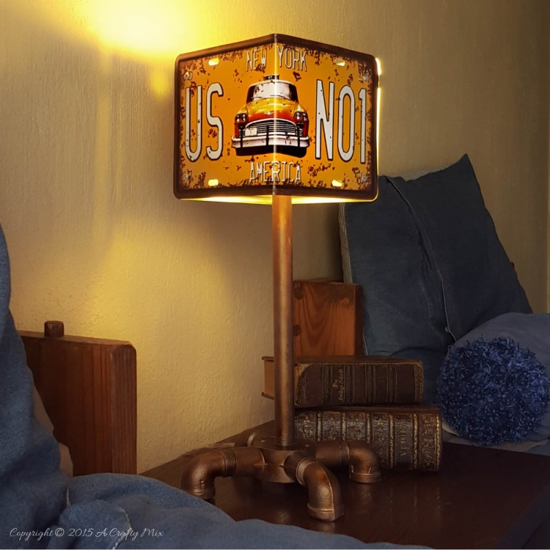Add a little industrial chic to your decor and make this license plate lamp using pipes. Perfect for a teens room or man cave. #ACraftyMix #DIYLamp