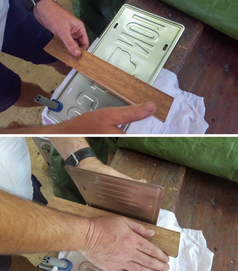 Use a piece of wood to bend the license plates at the half-way mark