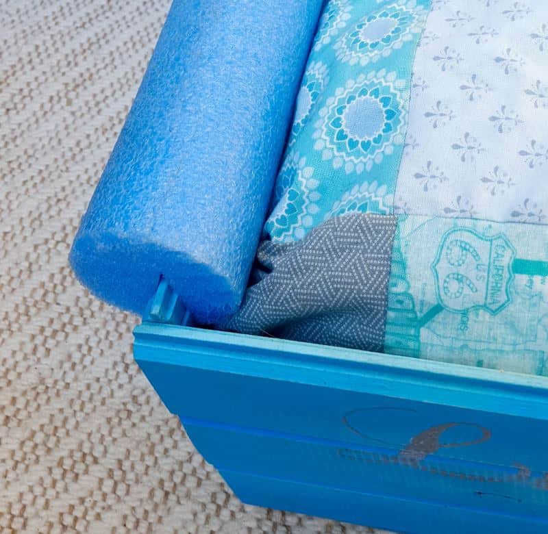Slice the pool noodle and slip it over the side