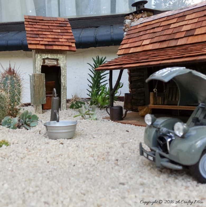 How to make a desert fairy garden and log cabin using a wooden tissue box. #DesertFairyGarden #FairyLogCabin #ACraftyMix #TissueBoxRepurpose