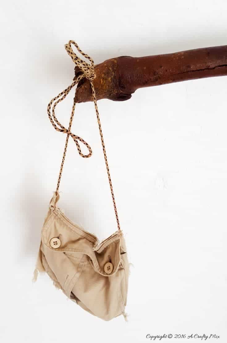 Hang a small pocket hand bag from the end to store all those bathroom goodies. #DIYHomeDecor #Branchtowelrack #branchrepurpose #DIYTutorial #DIYBathroomdecor #Acraftymix