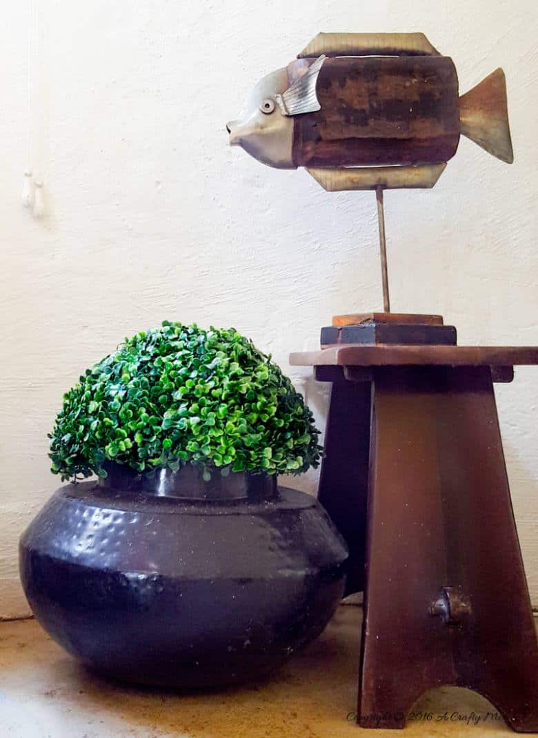A topiary on top of a metal urn hides our picnic blanket