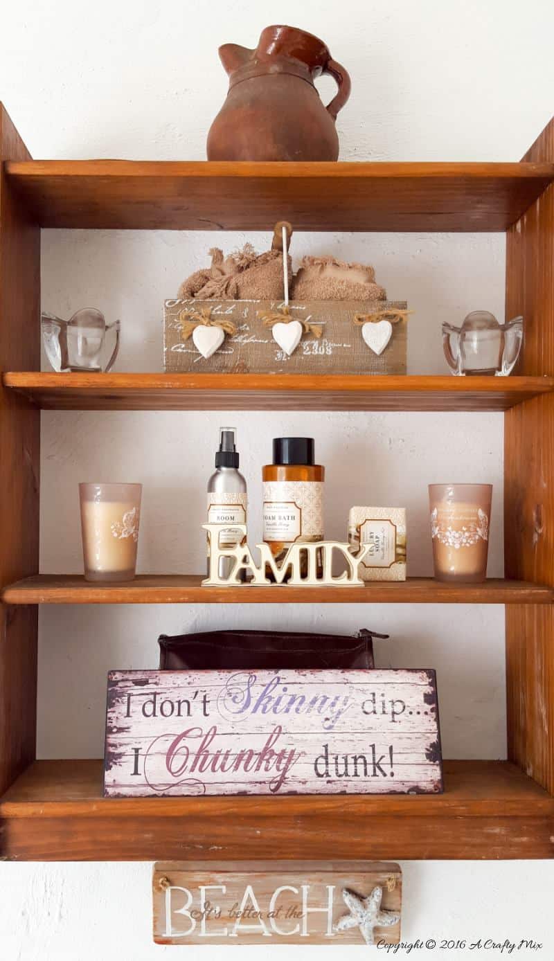 A thrifted shelf hung on the wall holds all our bathroom accessories #ACraftymix #StorageSolutions #SmallSpace