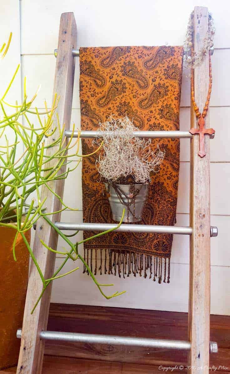 A throw and a little plant make a lovely statement on this easy to make industrial chic storage ladder #creativestorage #displayladder #industrialchic #storageladder
