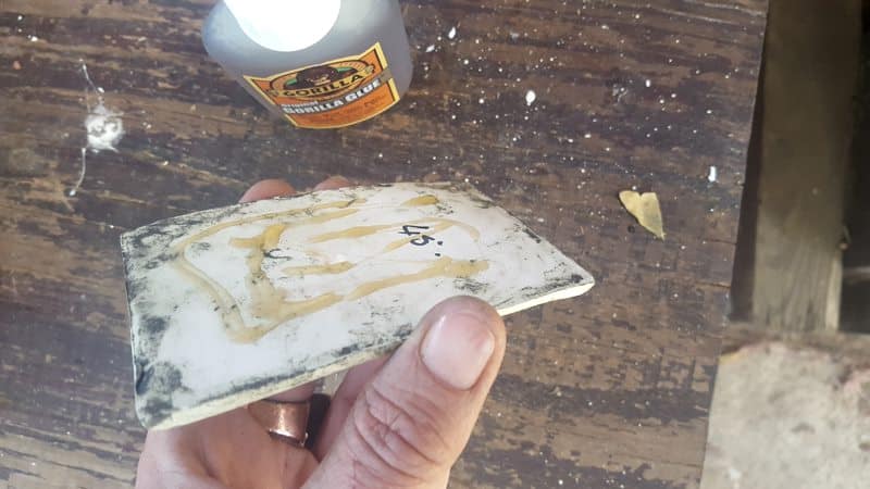 Add glue to the back of the tiles 