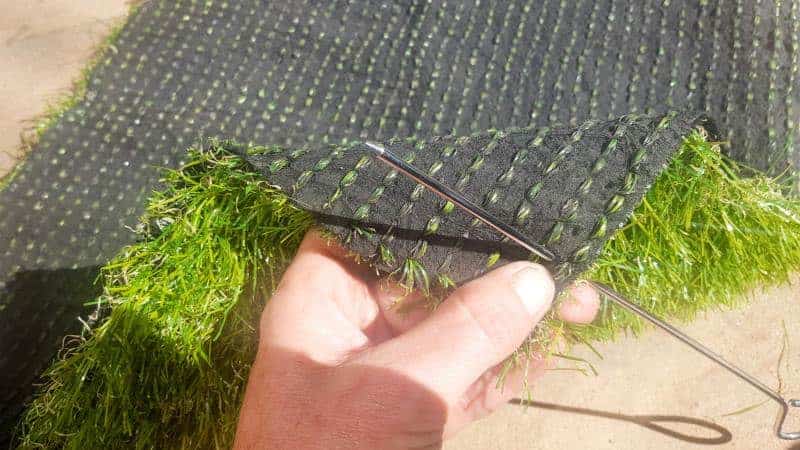 USe a skewer to make holes around the edge #DIYDoormat #CustomDoorMat #ACRaftyMix #OutdoorDoorMat #AstroTurfDoormat #DoormatTutorial