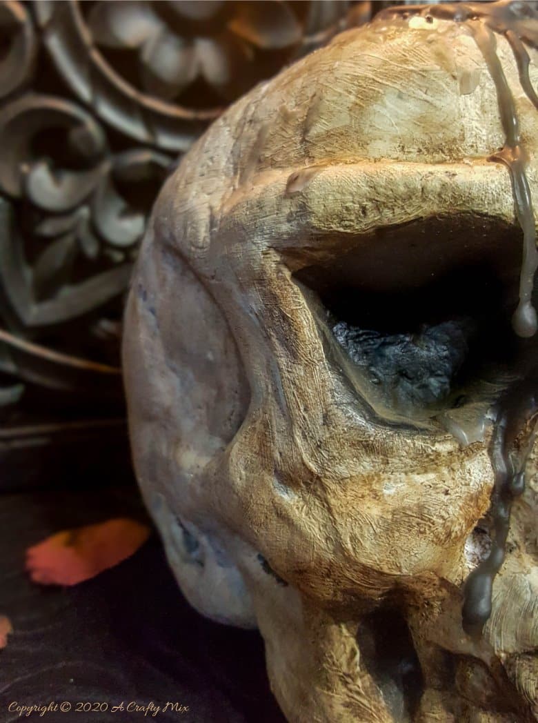 This easy to follow tutorial will show you how to age a Styrofoam or polystyrene skull and give it a spooktacular skull makeover. Can be used as a Halloween display or as a candle holder. #ACraftyMix