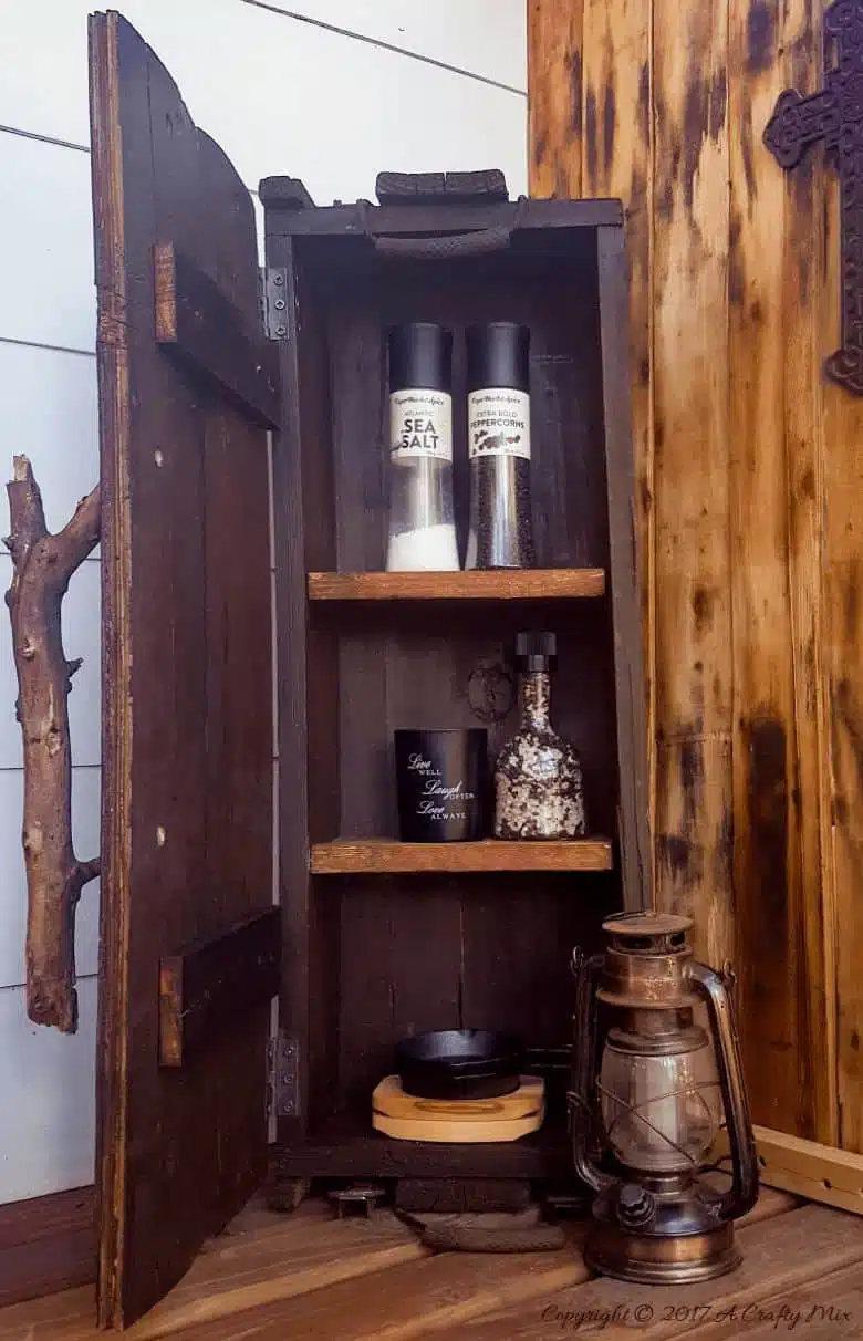 Turn a broken old ammo box into a small, sturdy kitchen cupboard. Perfect rustic home decor. This tutorial will also show you how to make a branch door handle #Repurpose #AmmoBox #ACraftyMix #RusticDecor #BranchUpcycle