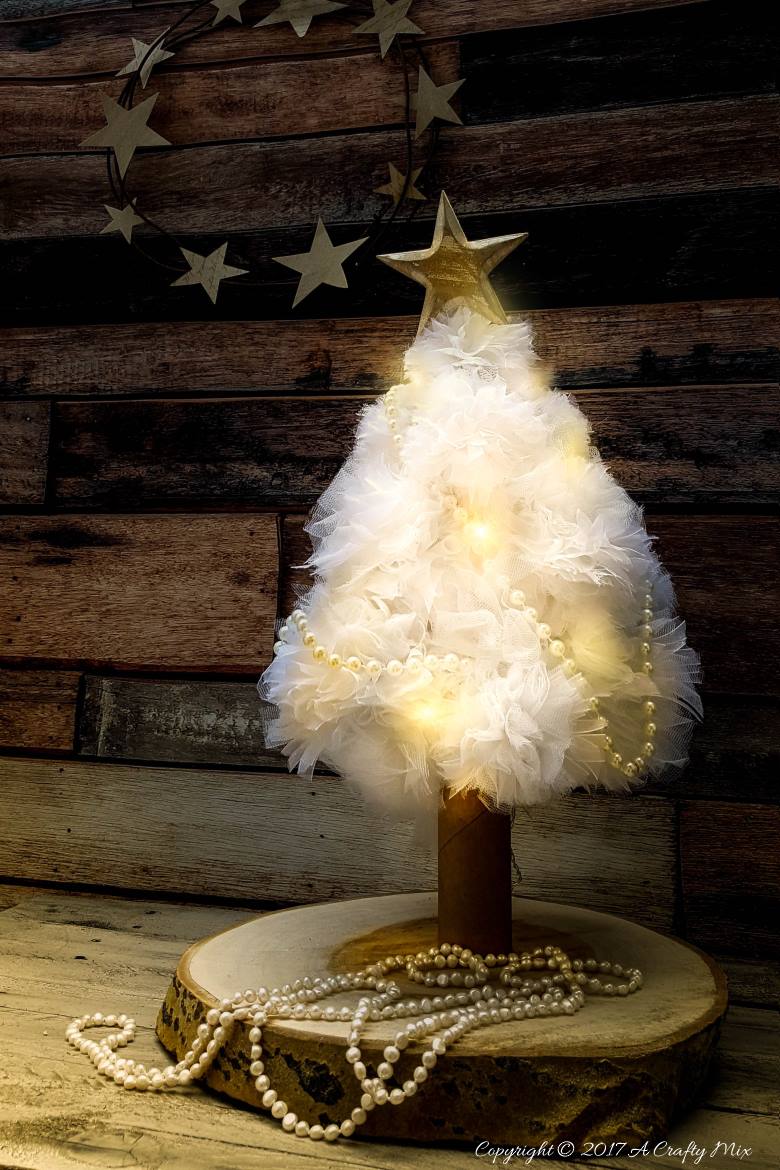 A quick and easy cat proof pom pom Christmas tree. I love how pretty it looks when it lights up at night. Christmas tree alternative ideas to make yourself #DIYChristmasTree #AlternativeChristmasTree #AcraftyMix #EasyCraftIdea #ChristmasDecor