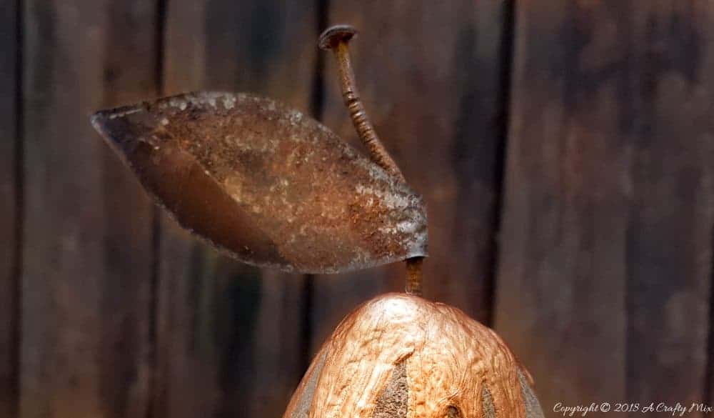 Close up of the pear stalk made from rusty metal and a nail