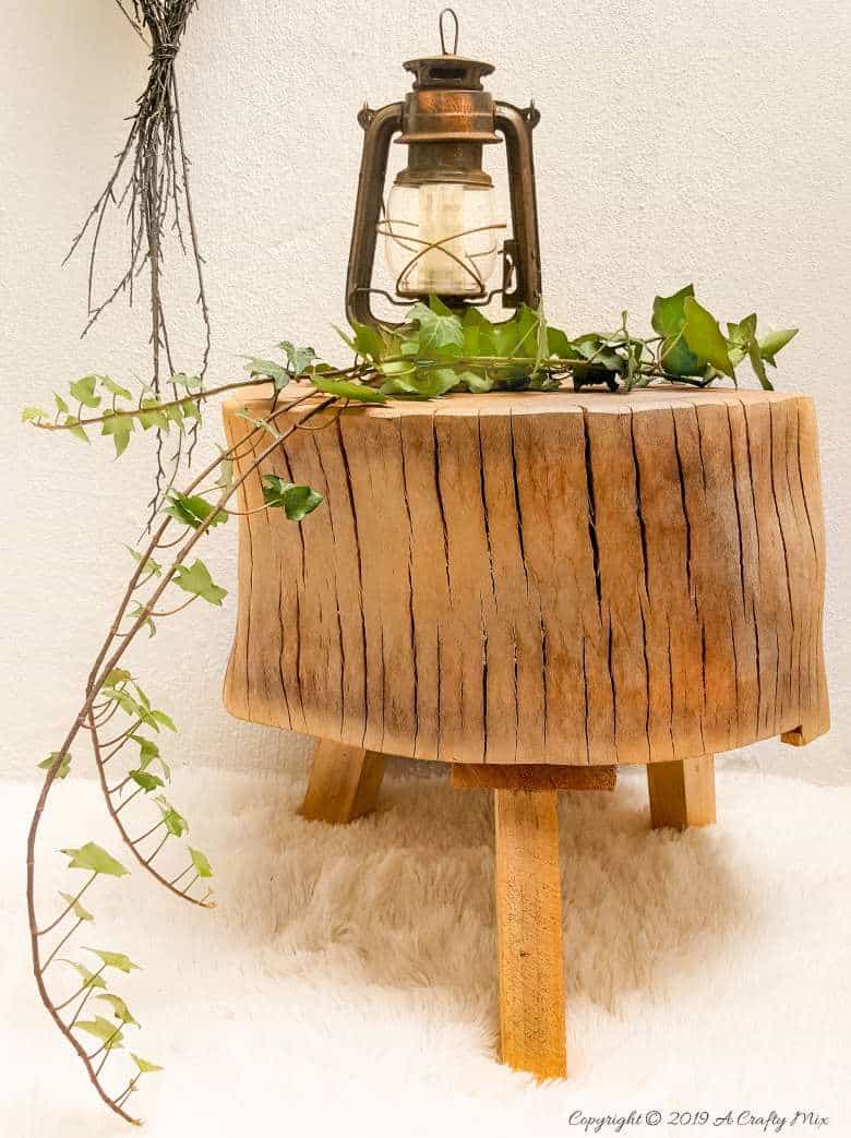 Gorgeous tree stump stool with ivy and an old lantern