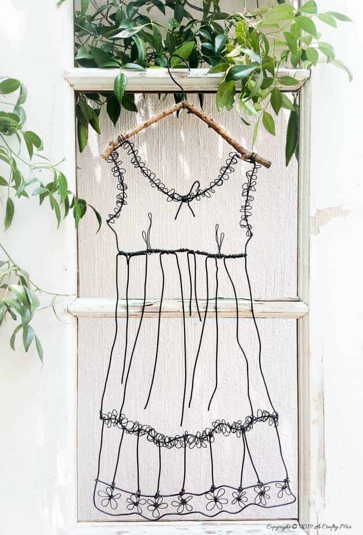 Add little elegance and whimsy to your wall art with this DIY wire dress tutorial. Made from jewelry wire, it's rustic and fun to do. Includes dress template and instructions for printing. Can be hung indoors or out. #WireArt #DIYTutorial #WallDecor