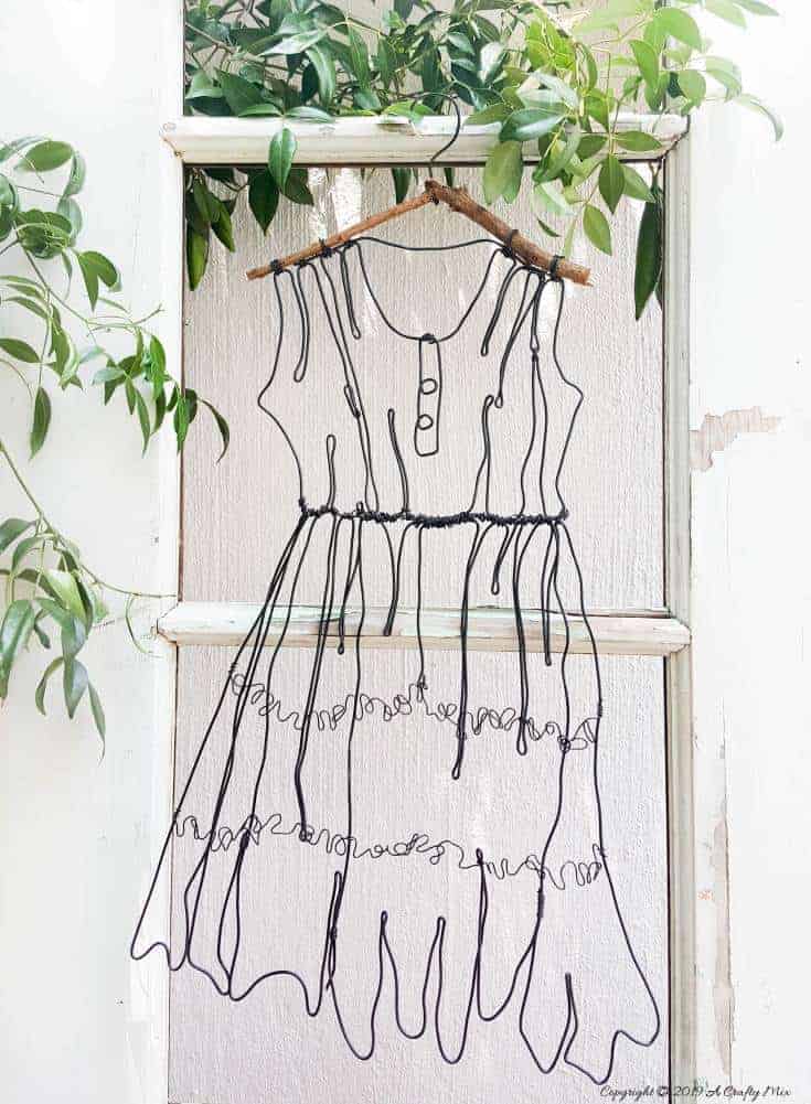Add little elegance and whimsy to your wall art with this DIY wire dress tutorial. Made from jewelry wire, it's rustic and fun to do. Includes dress template and instructions for printing. Can be hung indoors or out. #WireArt #DIYTutorial #WallDecor