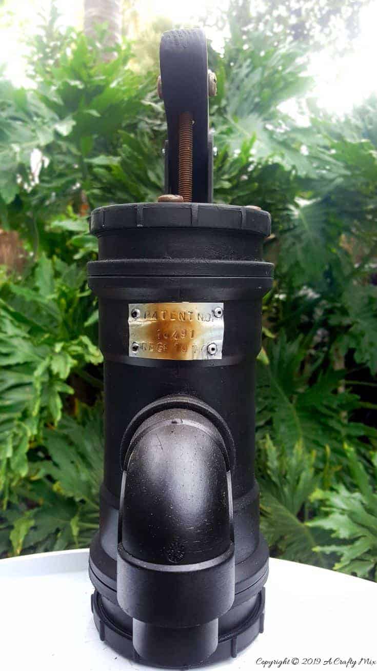 How to make your own faux antique hand water pump with metal patent stamp. #paintingPVCPipes #DIYPaintingPVC #acraftymix #DIYTutorial #fauxhandwaterpump #antiquewaterpump