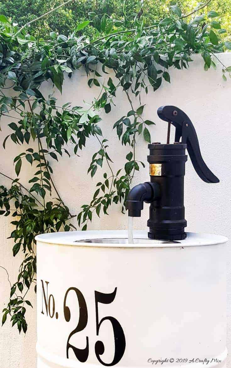 How to turn an empty drum into a unique water feature complete with a faux hand water pump made from PVC pipes  #drumwaterfeature #PVChandpump #DIYTutorial #ACraftyMix