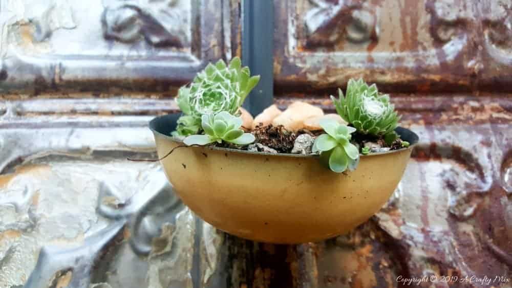 How to makeover an old plant stand using ceiling rusty tin ceiling tiles. Includes 3 ways to clean and prepare the tiles for craft projects #tinceilingideas #tinceilinghomedecor #tinceilingtilesrepurposed #plantstandideas #ACraftyMix