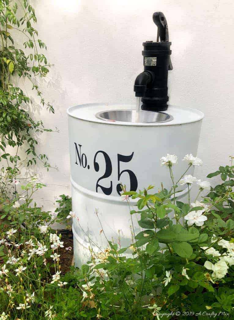 How to turn an empty drum into a unique water feature complete with a faux hand water pump made from PVC pipes #drumwaterfeature #PVChandpump #DIYTutorial #ACraftyMix #DIYWaterFeature #outdoorDIY