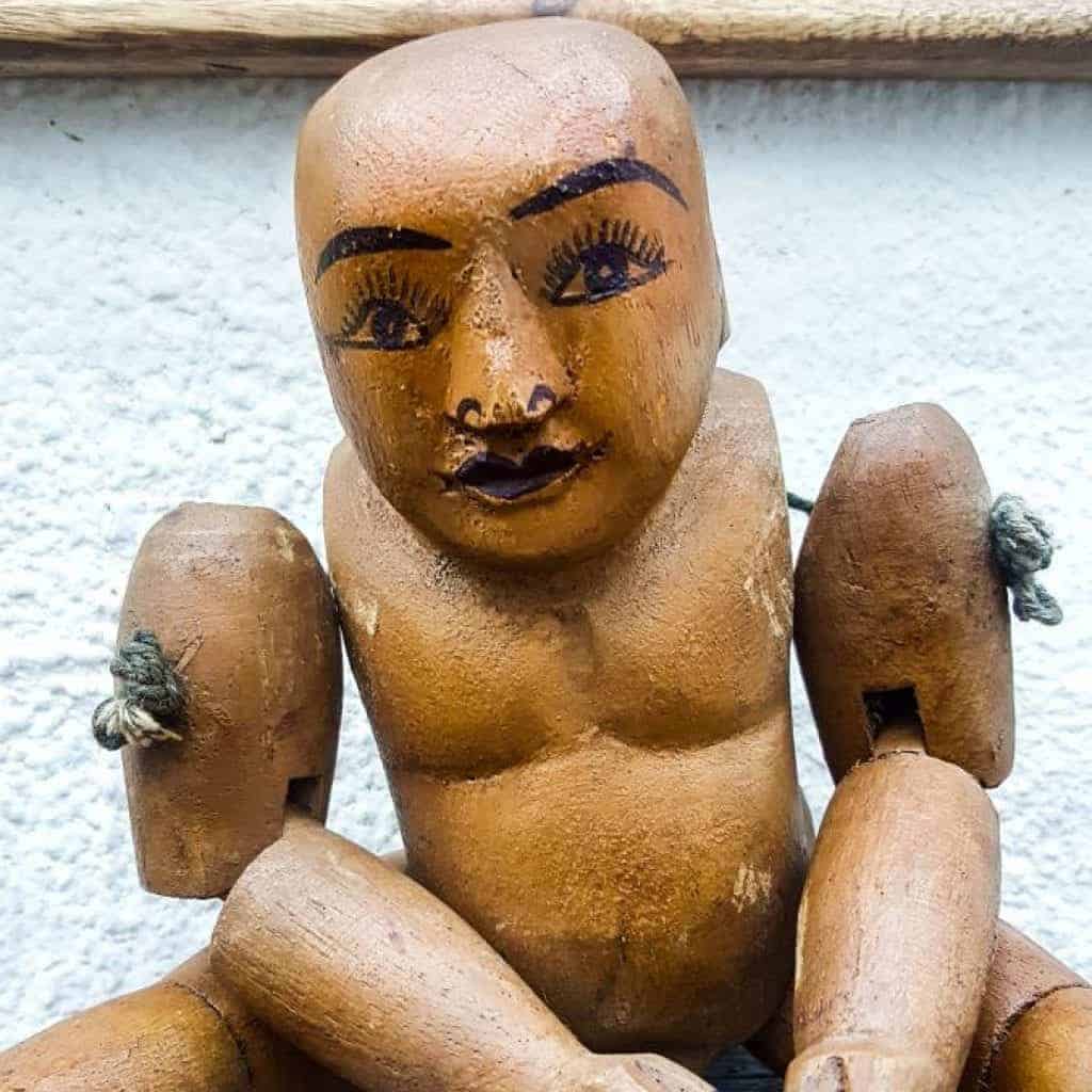 A cute little wooden puppet sits underneath the LUV wall decor #aCraftyMix #Walldecor