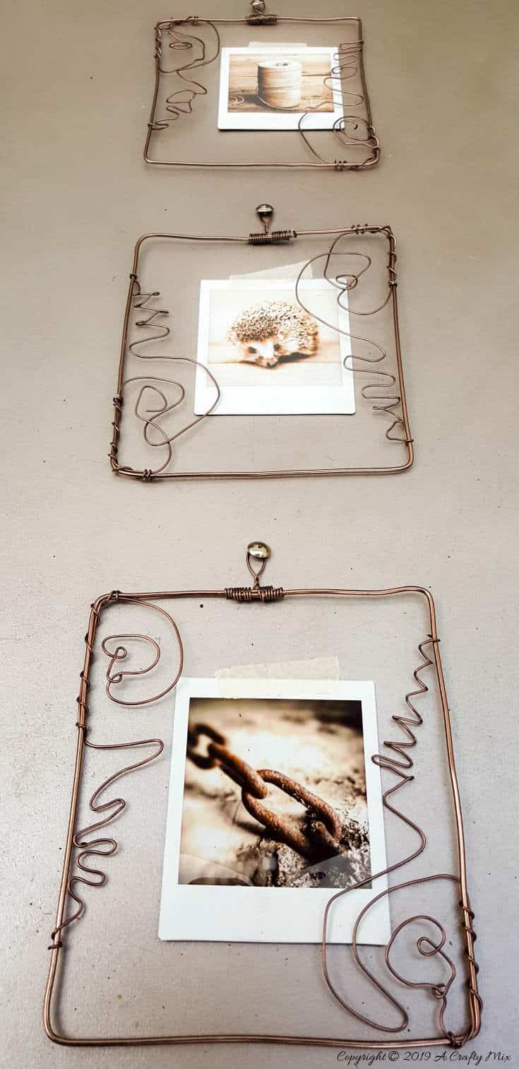 Upwards view of the three wire frames with instax prints #pictureframesDIY #wirepictureframe #pictureframes #gallerywall #creativepictureframes #polaroid #Fujifilm #Instax #ACraftyMix