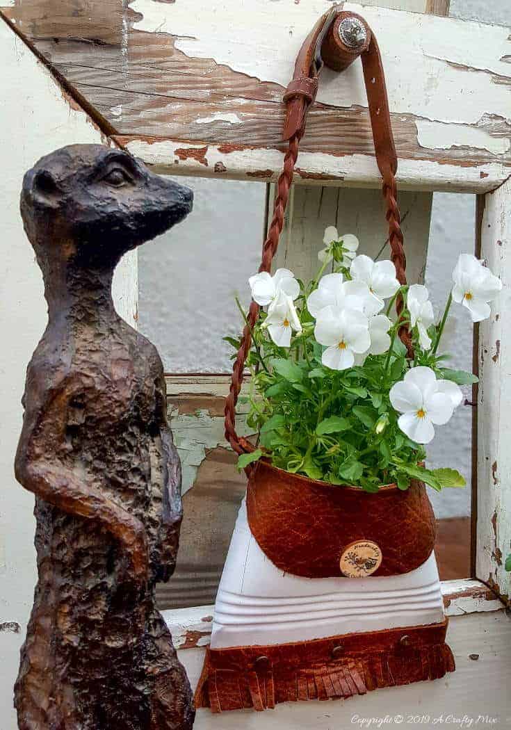 A close up of the meerkat and the tin can with pansies. So cute #tincan #recycle #repurpose #tincanrecycle #tincanplanter #acraftymix #creativetincanprojects #uniquetincanDIY