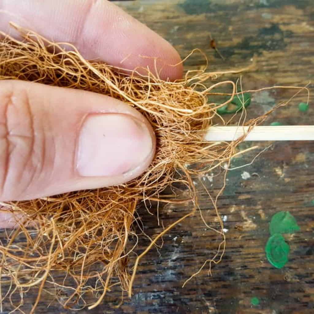 Adding the skewer for a broom handle #Halloweendecor #dollmakeover #spidergirl #acraftymix #halloweentutorial #halloweenDIY #witchlegs #grandinroad #miniaturehalloween