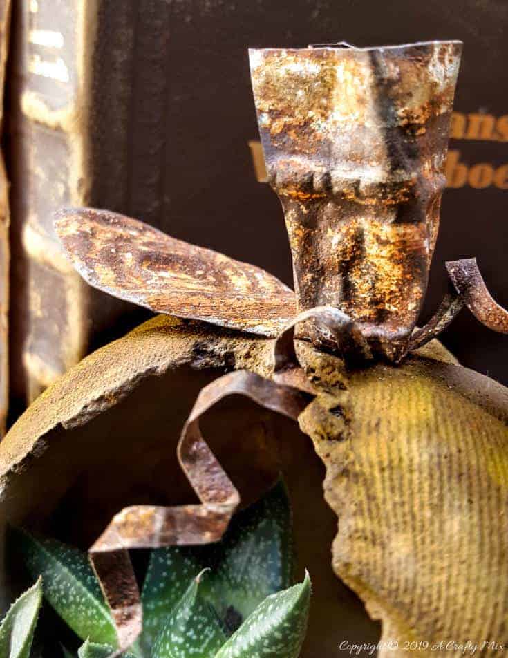 A close up of the tin ceiling stalk on the pumpkin planter. The rust compliments the mottled concrete stain beautifully #concreteplanter #concretepumpkin #stainedconcrete #concreteDIY #acraftymix #howtotutorial #succulentplanter #cementplanter
