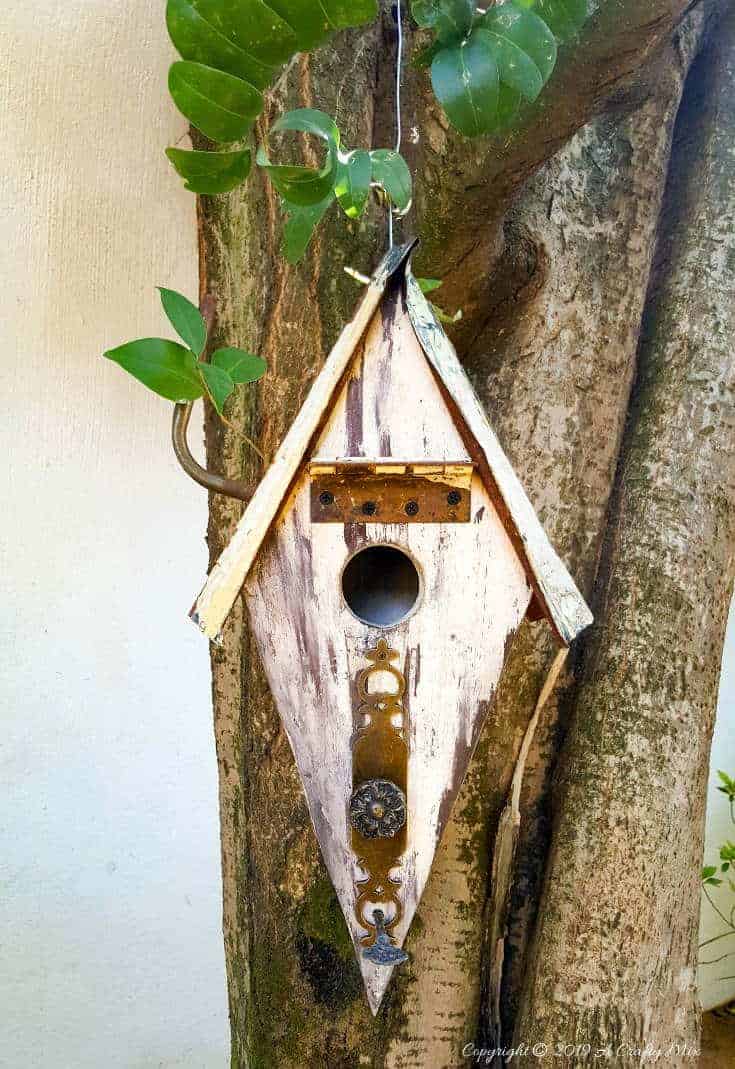 Want to add some rusty curb appeal or improve your backyard? This unique recycled birdhouse is made entirely from scrap bits and has so much character. It’s inexpensive and easy to make too The tutorial includes all the instructions to make your own. #rusticbirdhouse #DIYbirdhouse #paintedbirdhouse #acraftymix #birdhouseideas #uniquebirdhouse