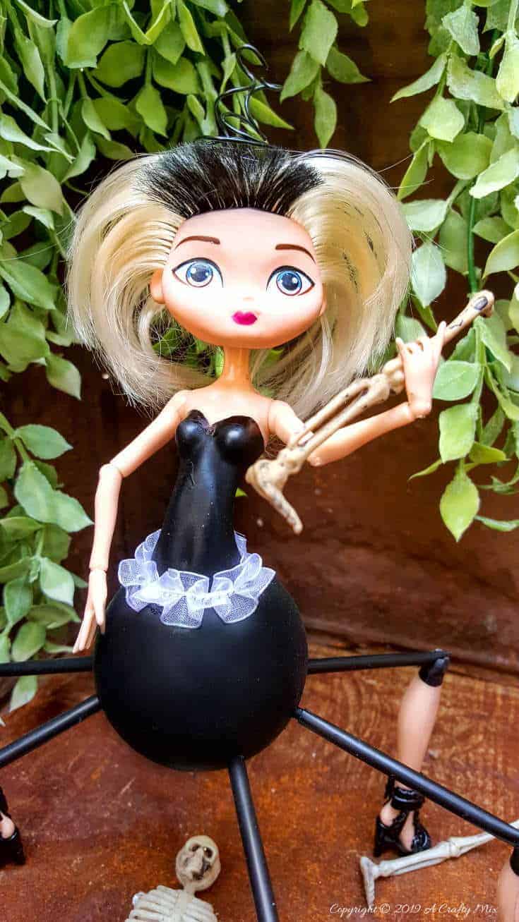 Do spiders freak you out? This easy to follow tutorial will show you how to give a cheap plastic doll a spider-girl makeover for Halloween that's a little freaky but oh so cute too #Halloweendecor #dollmakeover #spidergirl #acraftymix #halloweentutorial #halloweenDIY