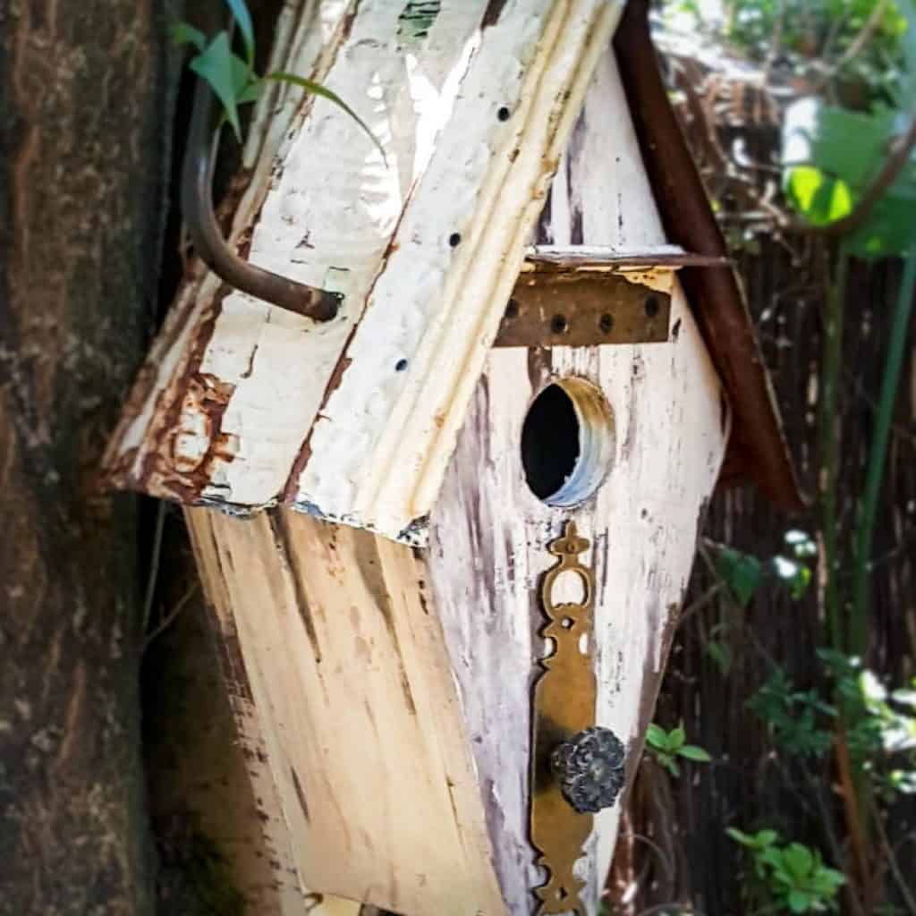 Want to add some rusty curb appeal or improve your backyard? This unique recycled birdhouse is made entirely from scrap bits and has so much character. It&rsquo;s inexpensive and easy to make too The tutorial includes all the instructions to make your own. #rusticbirdhouse #DIYbirdhouse #paintedbirdhouse #acraftymix #birdhouseideas #uniquebirdhouse