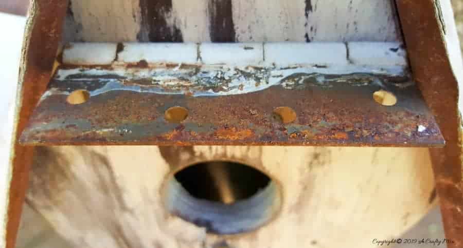 A close up view of the rusty metal hinge awning. #rusticbirdhouse #DIYbirdhouse #paintedbirdhouse #acraftymix #birdhouseideas #uniquebirdhouse
