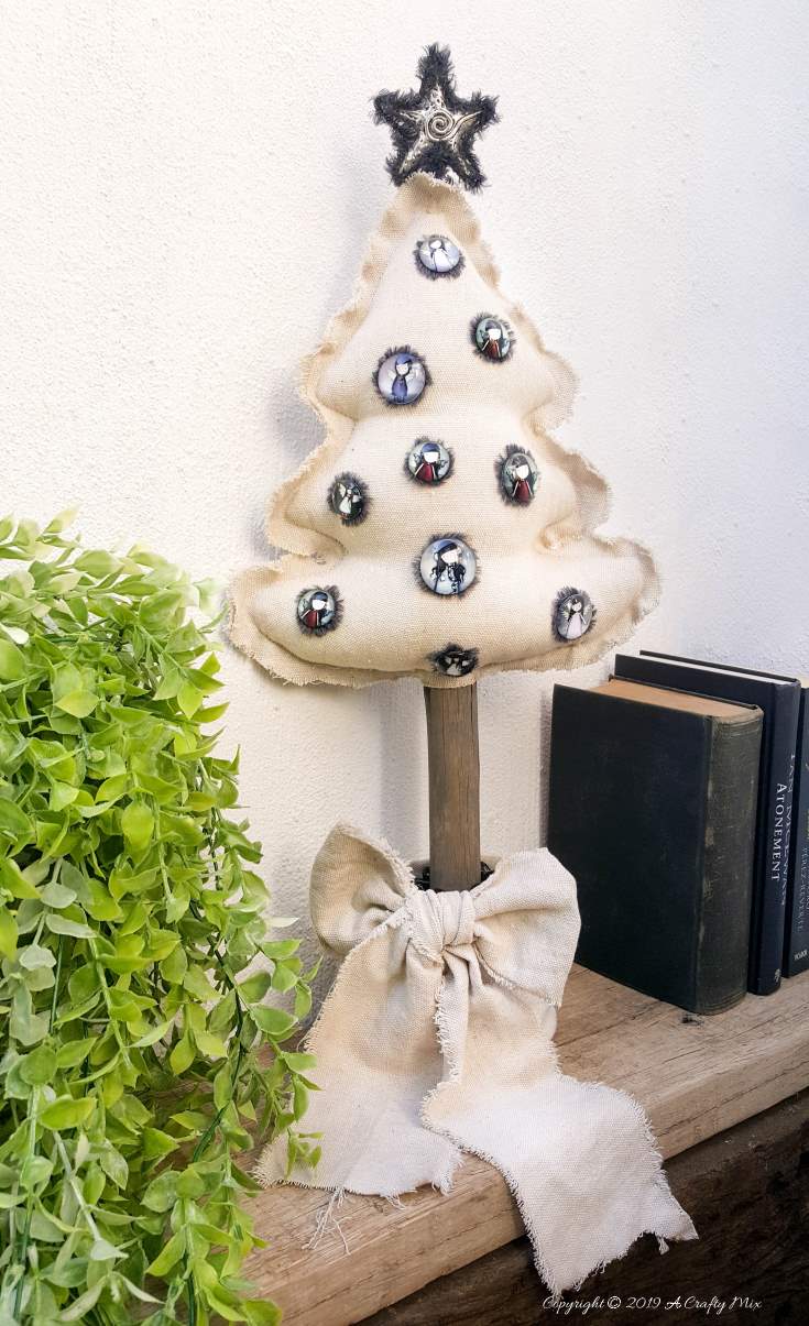 This Gorjuss inspired drop cloth Christmas tree doesn't even take an hour to make and it can be reused as a scatter cushion when the decorations come down. Perfect decor for small spaces #gorjuss #gorjussart #gorjussgirl #santorogorjuss #acraftymix #dropclothrepurpose #dropclothChristmas #dropclothDIY #dropclothcrafts #dropclothprojects