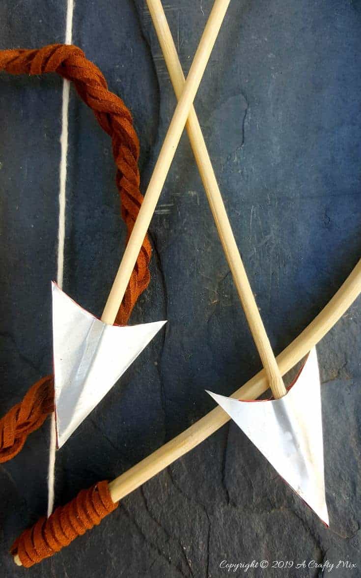 A close up of the bow and arrows made from empty soda tins #VintageValentine #TinCanRecycle #ValentineGiftIdea #QuiverArrows #AcraftyMix #HomeDecor #MacrameArrow