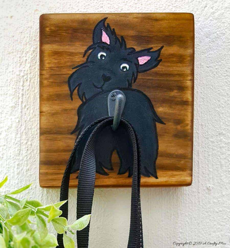 Make an adorable and easy DIY Dog Leash holder using a scrap piece of wood and craft paint. You and your fur baby will love it and the tutorial includes a free printable! #DIYDogLeash #Leashholderideas #WoodLeashHolder #ACraftyMix #FreePrintable #ScottishTerrier #PetLeashHolder #DIYLeashHolder