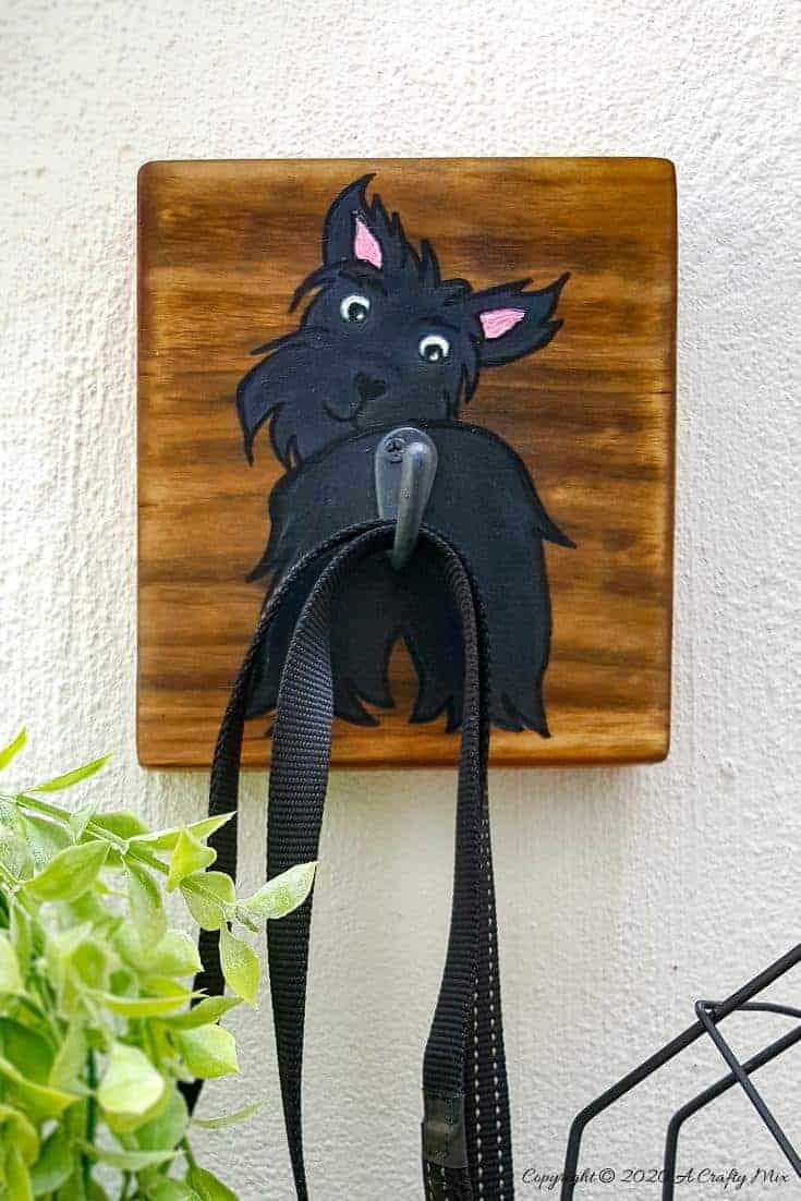 Make an adorable and easy DIY Dog Leash holder using a scrap piece of wood and craft paint. You and your fur baby will love it and the tutorial includes a free printable! #DIYDogLeash #Leashholderideas #WoodLeashHolder #ACraftyMix #FreePrintable #ScottishTerrier #PetLeashHolder #DIYLeashHolder