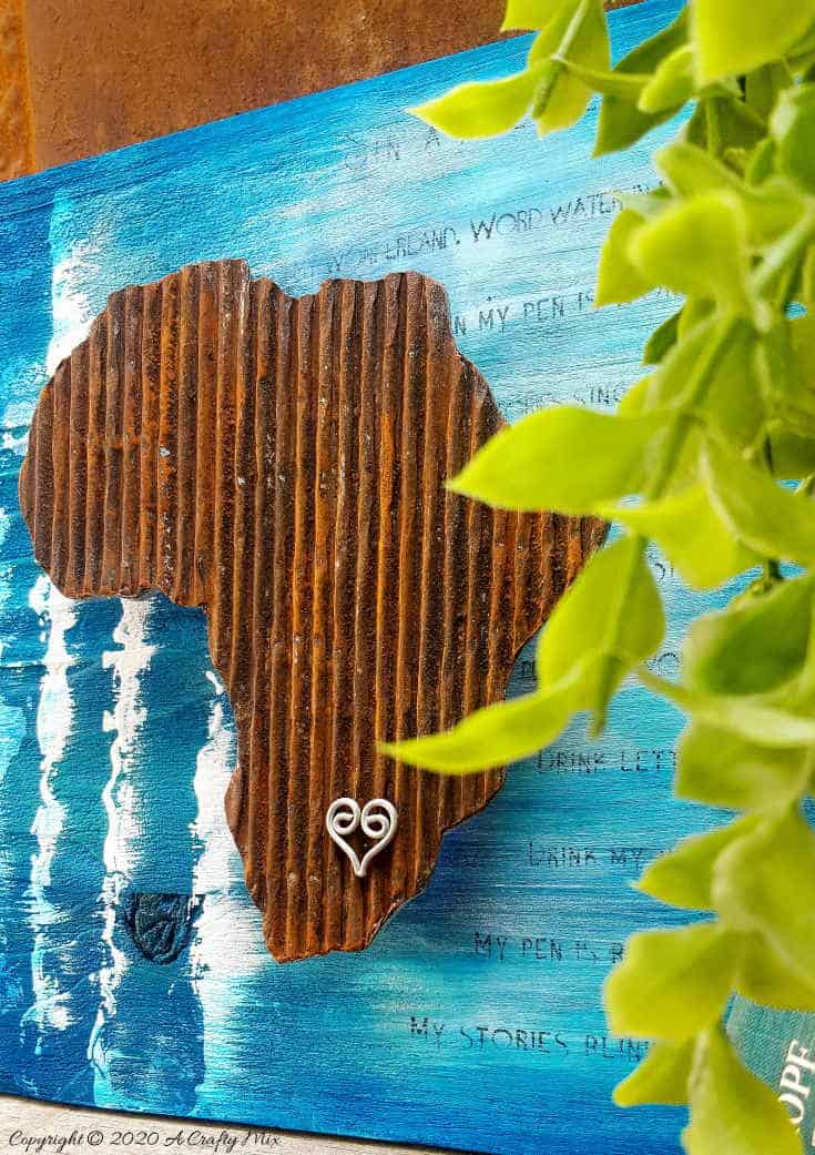 Mixed media pieces are always fun to put together and the possibilities are endless. This tutorial will show you how to make cardboard look like a rusty sheet of metal and turn your mixed media into a night light. #mixedmedia #mixedmediatutorial #DIYNightLight #ACraftyMix #fauxrust #Africa #HomeDecor