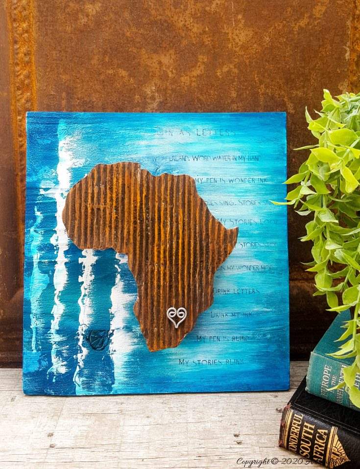 Mixed media pieces are always fun to put together and the possibilities are endless. This tutorial will show you how to make cardboard look like a rusty sheet of metal and turn your mixed media into a night light. #mixedmedia #mixedmediatutorial #DIYNightLight #ACraftyMix #fauxrust #Africa #HomeDecor