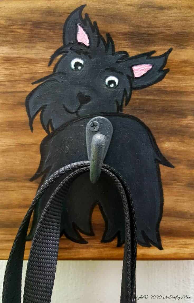 Make an adorable and easy DIY Dog Leash holder using a scrap piece of wood and craft paint. You and your fur baby will love it and the tutorial includes a free printable! #DIYDogLeash #Leashholderideas #WoodLeashHolder #ACraftyMix #FreePrintable #ScottishTerrier #PetLeashHolder #DIYLeashHolder