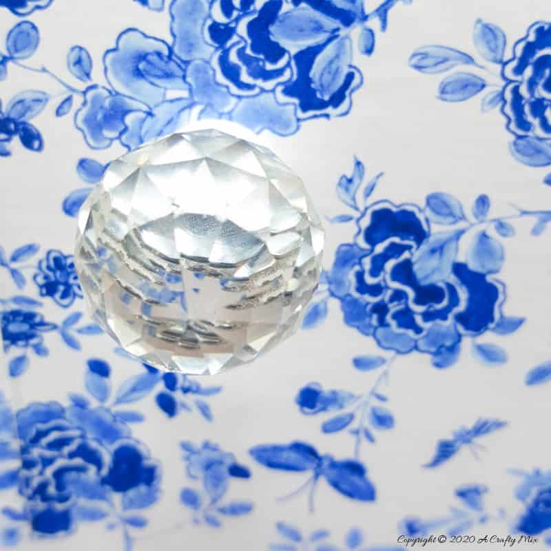 Beautiful crystal doorknobs compliment the look of the Chinoiserie vinyl tiles #ChinoiserieDecor #VinylTile #EasyMakeOver #HomeDecorDIY #chinoiserietiles #ACraftyMix #blueandwhitedecor #chinoiseriechic #VinylTileDecor #DIYTutorial