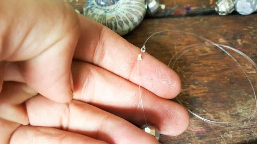 Use bead crimpers (crimp tubes) to space the beads on the fishing line #DIYDenim #DenimIdeas #DenimMobile #DenimUpcycleIdeas #ACraftyMix #DenimUpcycle #DIYWindChime #TinCanRecycle #TinCanMobile #DenimWindChime