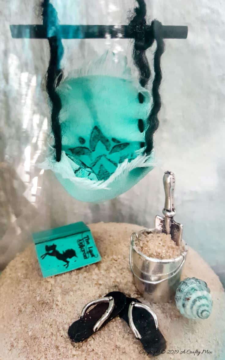 How to recycle a broken wine glass and make a fairy beach in a cloche #FairyGarden #FairyGardenIdeas #ACraftyMix #FairyGardenDIY #FairyBeachDIY #FairyGardenDesigns #ClocheDecor #ClocheIdeas #WineGlassCloche #ClocheDIY #WineGlassRepurpose #UnicornSPiT