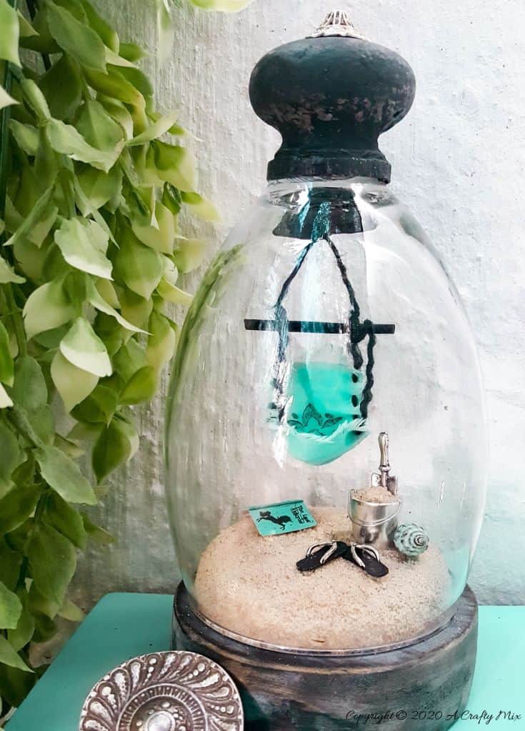 How to recycle a broken wine glass and make a fairy beach in a cloche #FairyGarden #FairyGardenIdeas #ACraftyMix #FairyGardenDIY #FairyBeachDIY #FairyGardenDesigns #ClocheDecor #ClocheIdeas #WineGlassCloche #ClocheDIY #WineGlassRepurpose #UnicornSPiT