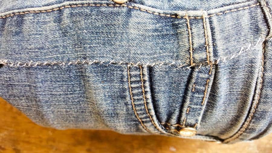 Hand sew the denim around the tin can. You can also use fabric adhesive #DIYDenim #DenimIdeas #DenimMobile #DenimUpcycleIdeas #ACraftyMix #DenimUpcycle #DIYWindChime #TinCanRecycle #TinCanMobile #DenimWindChime