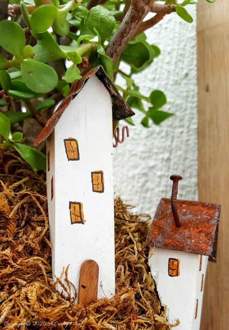 Take your moss ball string garden to the next level with this cute kokedama fairy village. Easy to make and customize. #EcoFriendly #Kokedama #FairyVillage #ACraftyMix #EasyGardenCraft #MossBalls #SpekBoom #kokedamaIdeas #StringGarden #IndoorPlants