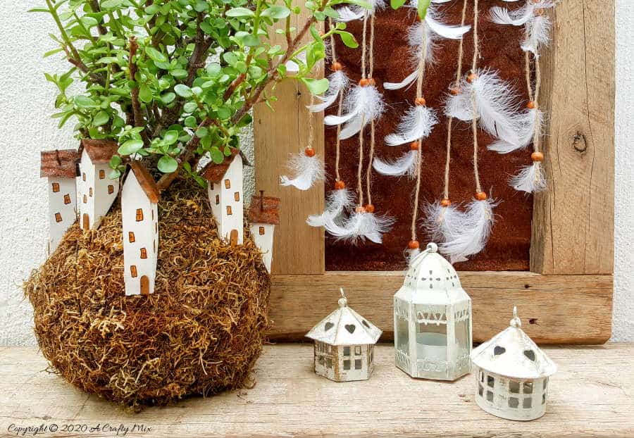 Take your moss ball string garden to the next level with this cute kokedama fairy village. Easy to make and customize. #EcoFriendly #Kokedama #FairyVillage #ACraftyMix #EasyGardenCraft #MossBalls #SpekBoom #kokedamaIdeas #StringGarden #IndoorPlants