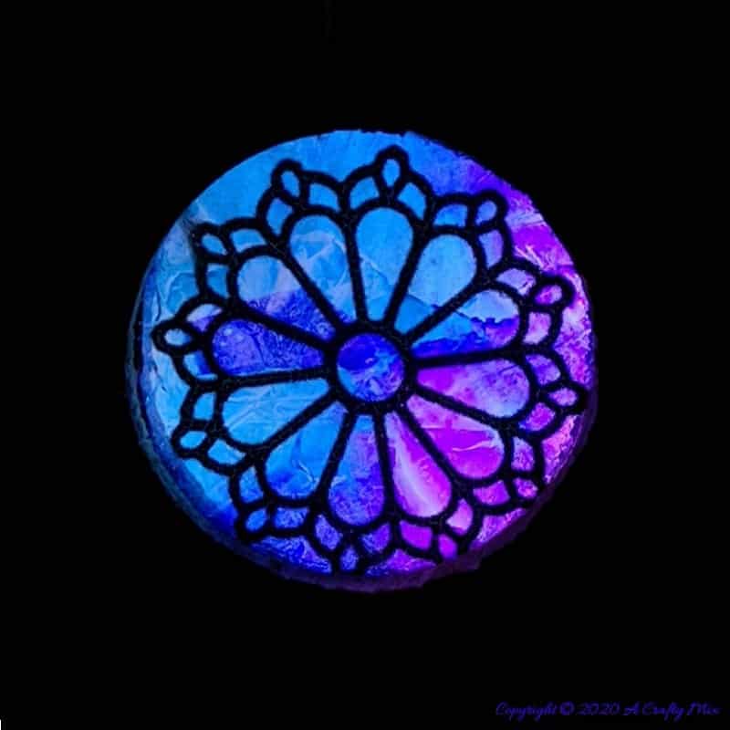 Welcome the fae folk into your home with this gorgeous stained glass fairy door. Made with things you probably already have in your craft cupboard the door doubles up as a night light. #FairydoorDIY #FairyDoorIdeas #ACraftyMix #MakeAFairyDoor #MiniatureStainedGlass #AlcoholInk